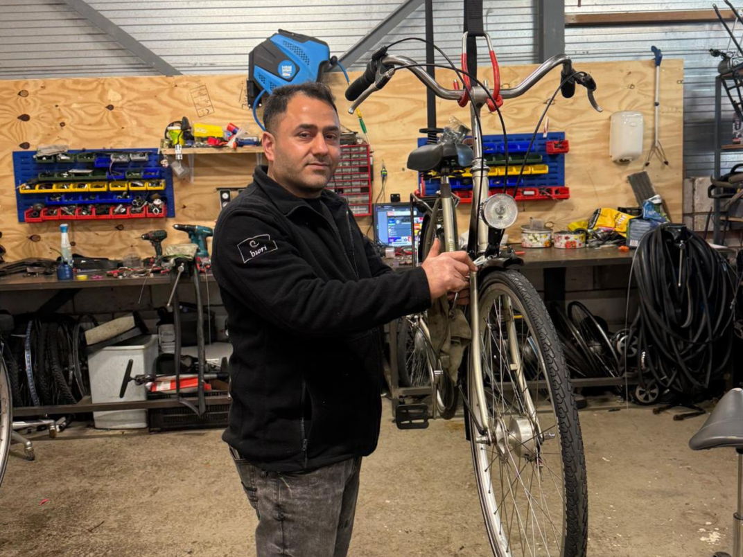 Man die een fiets repareert