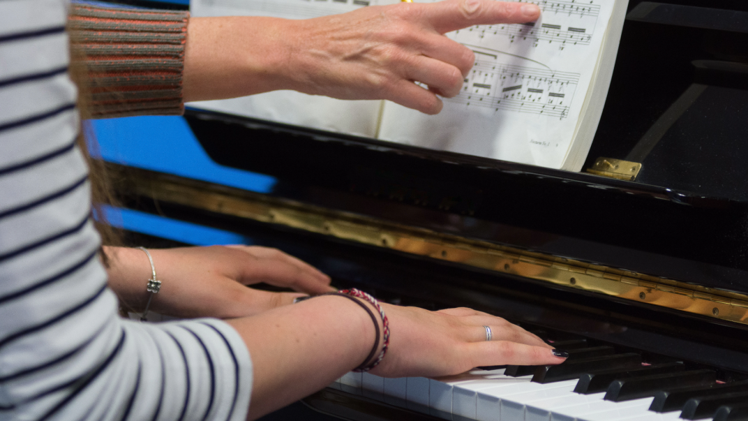 Persoon krijgt pianoles