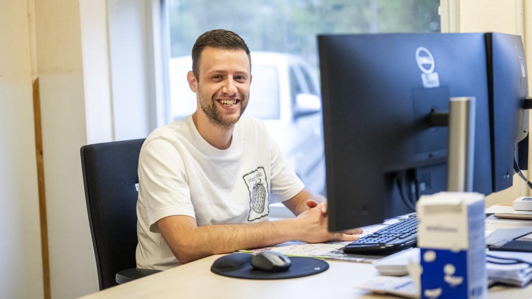 Man zit achter computerschermen.