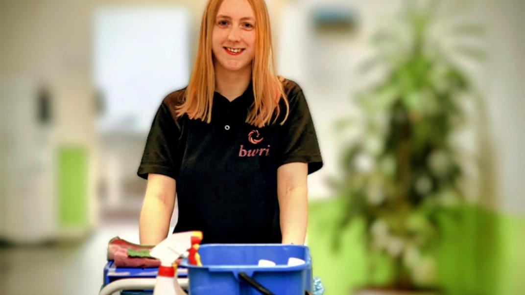 Iemand achter een schoonmaak kar 